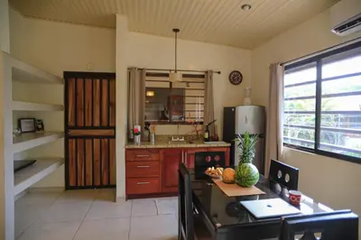 a kitchen with a table and a refrigerator in it at Beach Break Santa Teresa Apartamentos in Santa Teresa Beach