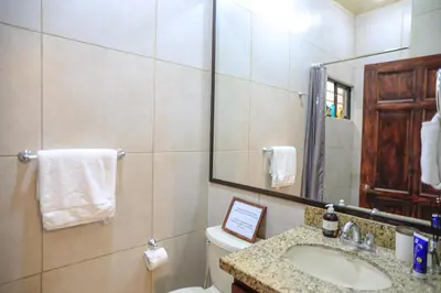 a bathroom with a sink and a toilet and a mirror at Beach Break Santa Teresa Apartamentos in Santa Teresa Beach