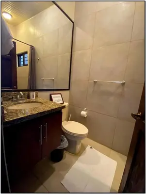 a bathroom with a toilet and a sink and a mirror at Beach Break Santa Teresa Apartamentos in Santa Teresa Beach