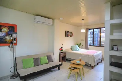 a bedroom with a bed and a couch in a room at Beach Break Santa Teresa Apartamentos in Santa Teresa Beach