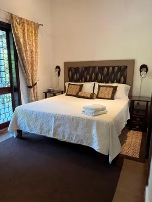 a bedroom with a large bed and a window at COTTON HOUSE DE LABRADOR in Labrador