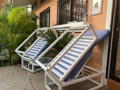 two beach chairs sitting outside of a house at Spacious Loft with Pool and Great Outdoor Areas in Coco