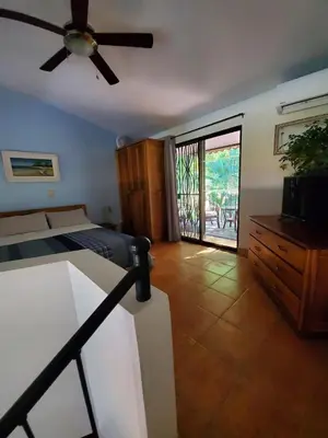 a bedroom with a bed and a ceiling fan at Spacious Loft with Pool and Great Outdoor Areas in Coco