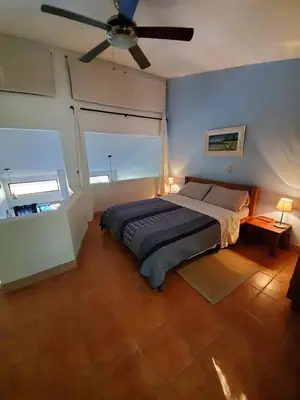 a bedroom with a bed and a ceiling fan at Spacious Loft with Pool and Great Outdoor Areas in Coco