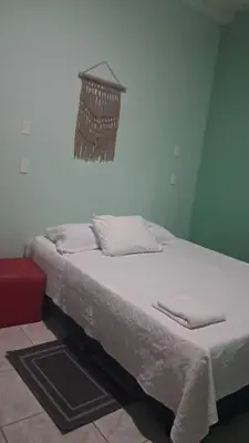 a bedroom with a bed with white sheets and a hanging basket at apartamento 3 in Fortuna