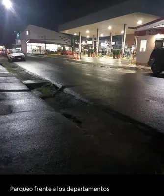 an empty street at night with a gas station at La Estancia Ideal Apartamentos in Fortuna