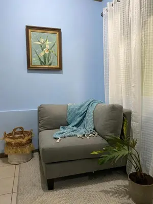 a blue room with a couch with a blanket on it at La Estancia Ideal Apartamentos in Fortuna