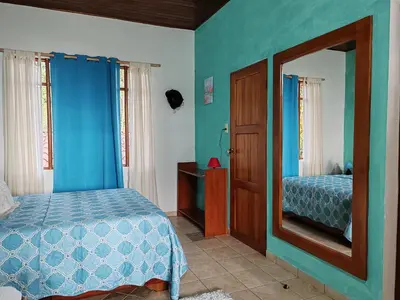 a bedroom with a bed and a mirror at La Ceiba Tree Lodge in Tilarán