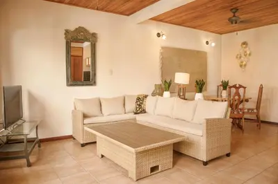 a living room with a couch and a tv at Apartotel Girasol in Jacó