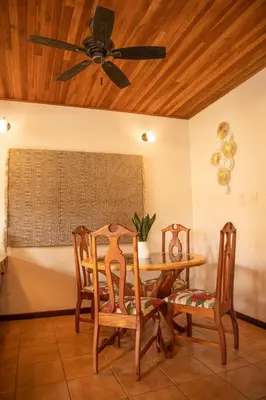 a dining room with a ceiling fan and a table and chairs at Apartotel Girasol in Jacó