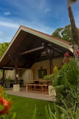a pavilion with a picnic table in a garden at Apartotel Girasol in Jacó