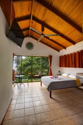a bedroom with a bed and a large window at Apartotel Girasol in Jacó