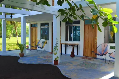 a patio with chairs and a table in a house at Hotel Pura Natura Beachfront Tortuguero in Tortuguero