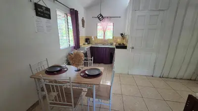 a kitchen with a table and chairs and a door at Villasjungle 1 in Sámara