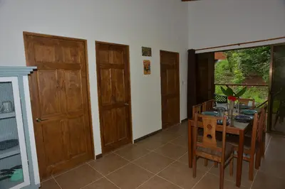 a dining room with a table and wooden doors at Villasjungle 2 in Sámara