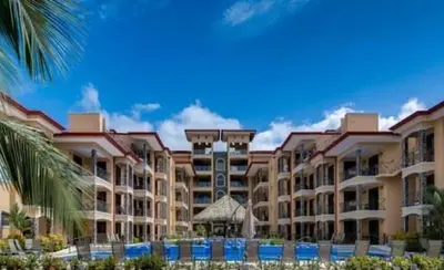 a view of a resort with a palm tree at 777J Beachfront Luxury Condo 3 BR/2.5BA Near SJO - Jaco Beach in Jacó