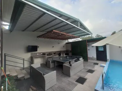 a patio with a swimming pool and a patio table and chairs at Casa Linda in Uvita