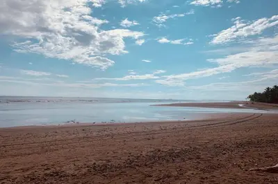 a beach with water and clouds in the sky at Casa Linda in Uvita