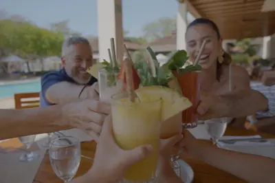 a group of people sitting at a table with drinks at Villa Zindagi Luxury Villa Private Pool - Reserva Conchal in Playa Conchal