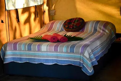a bed with two roses and a basket on it at El Pulpo Safari Lodge in Ojochal