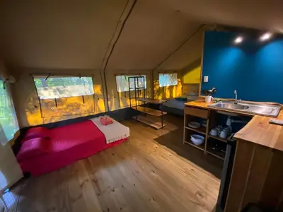 a room with a bed and a sink in a tent at El Pulpo Safari Lodge in Ojochal