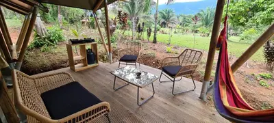 a screened porch with chairs and a table and a grill at El Pulpo Safari Lodge in Ojochal