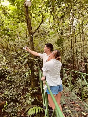 a man taking a picture of a woman on a bridge at Ávita Lodge in Quesada