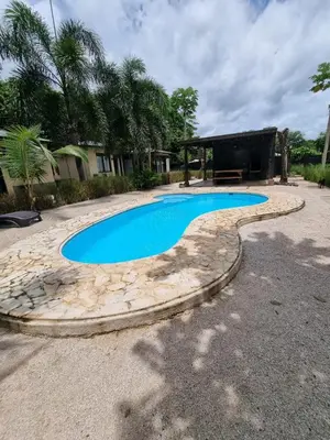 a swimming pool with a stone path around it at Beach Walk Costa Rica in Playa Avellana