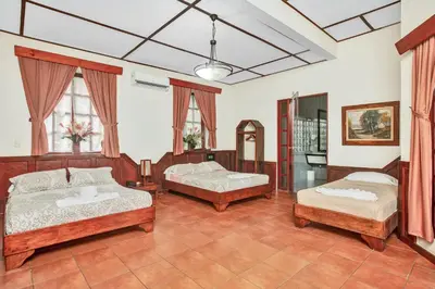 a bedroom with two beds and a mirror at Hotel Playa Bejuco in Esterillos Este
