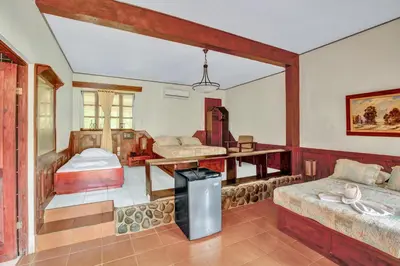 a room with two beds and a table in it at Hotel Playa Bejuco in Esterillos Este