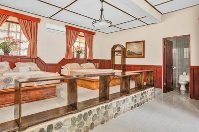 a large room with two beds and a bathroom at Hotel Playa Bejuco in Esterillos Este