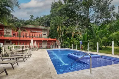 a swimming pool in front of a building at Hotel Playa Bejuco in Esterillos Este