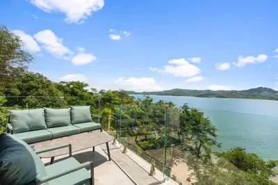 a view of the water from the balcony of a house at 5-BD Beachfront, Ocean-View Hillside Home in Playa Flamingo