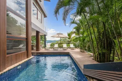 an infinity pool in a villa with a house at 5-BD Beachfront, Ocean-View Hillside Home in Playa Flamingo