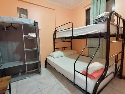 a room with two bunk beds and a window at Marta's Guesthouses, apartamentos con entrada autonoma in Puerto Limón