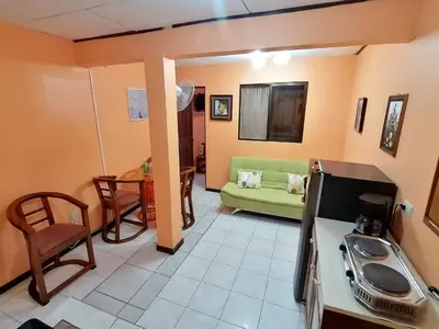 a living room with a green couch and a table at Marta's Guesthouses, apartamentos con entrada autonoma in Puerto Limón