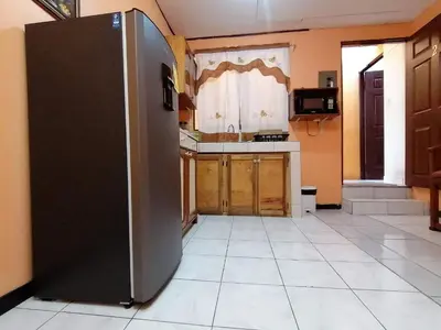 a kitchen with a refrigerator in the middle of a room at Marta's Guesthouses, apartamentos con entrada autonoma in Puerto Limón