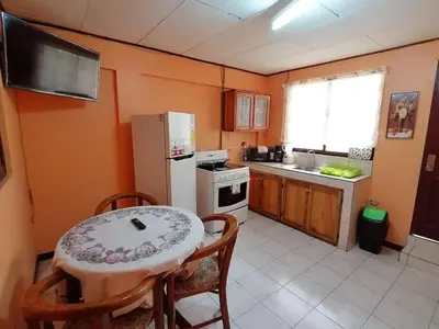 a small kitchen with a table and a refrigerator at Marta's Guesthouses, apartamentos con entrada autonoma in Puerto Limón