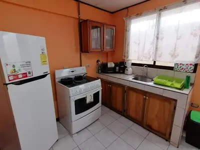 a small kitchen with a stove and a refrigerator at Marta's Guesthouses, apartamentos con entrada autonoma in Puerto Limón