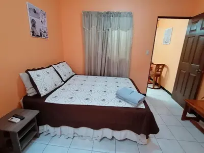 a bedroom with a bed in a room with orange walls at Marta's Guesthouses, apartamentos con entrada autonoma in Puerto Limón
