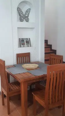 a dining room table with a butterfly on the wall at La Casita de Naomi in Tamarindo