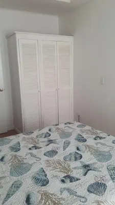 a bedroom with a bed with a blue and white quilt at La Casita de Naomi in Tamarindo