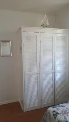a white closet with white doors in a bedroom at La Casita de Naomi in Tamarindo