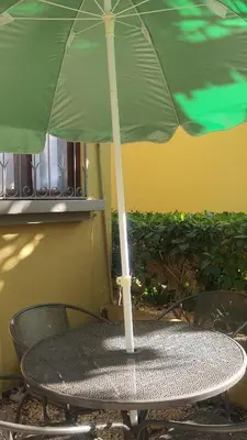 a green umbrella sitting on top of a table at La Casita de Naomi in Tamarindo