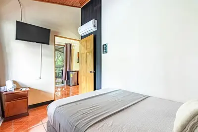 a bedroom with a bed and a flat screen tv at Rio Danta in Fortuna