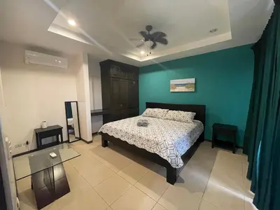 a bedroom with a bed and a blue wall at Family oriented house just steps to the beach in Jacó