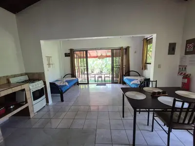 a living room with a table and chairs and a kitchen at Villasjungle 3 in Sámara