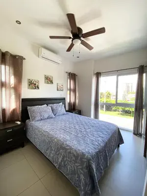 a bedroom with a blue bed with a ceiling fan at Hermoso Condominio en el Centro de Jaco Lapa Living in Jacó