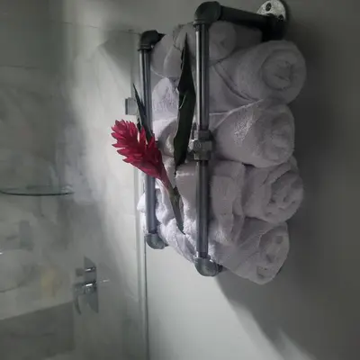 a red flower is on a wall with towels at MADRE TERRA in Uvita