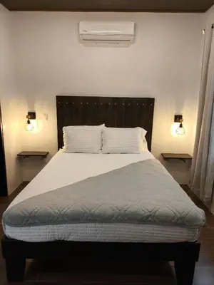 a bedroom with a large bed with two lights at MADRE TERRA in Uvita